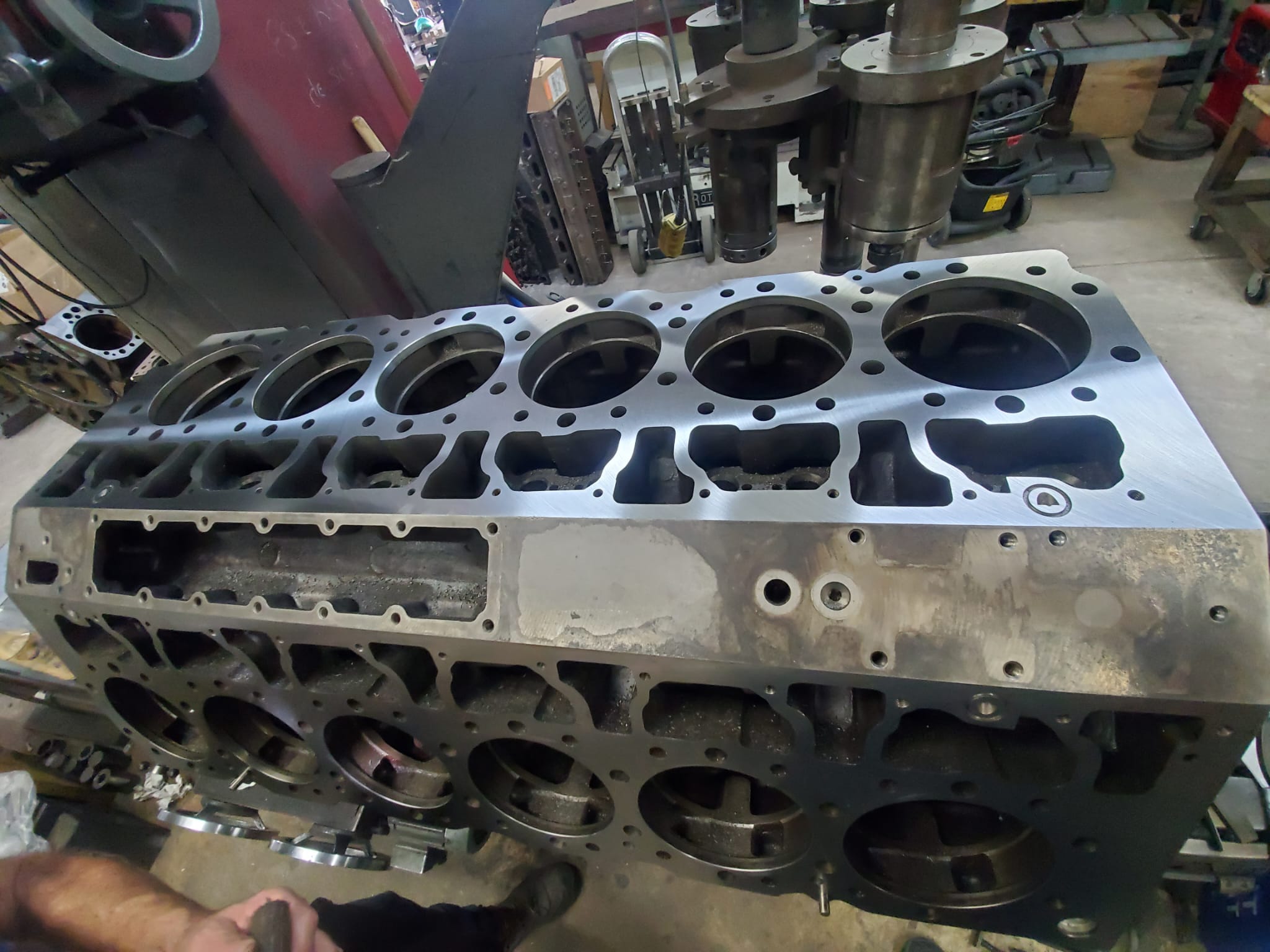 Technician cleaning a diesel engine block before inspection and machining at Motor Service Group in Miami