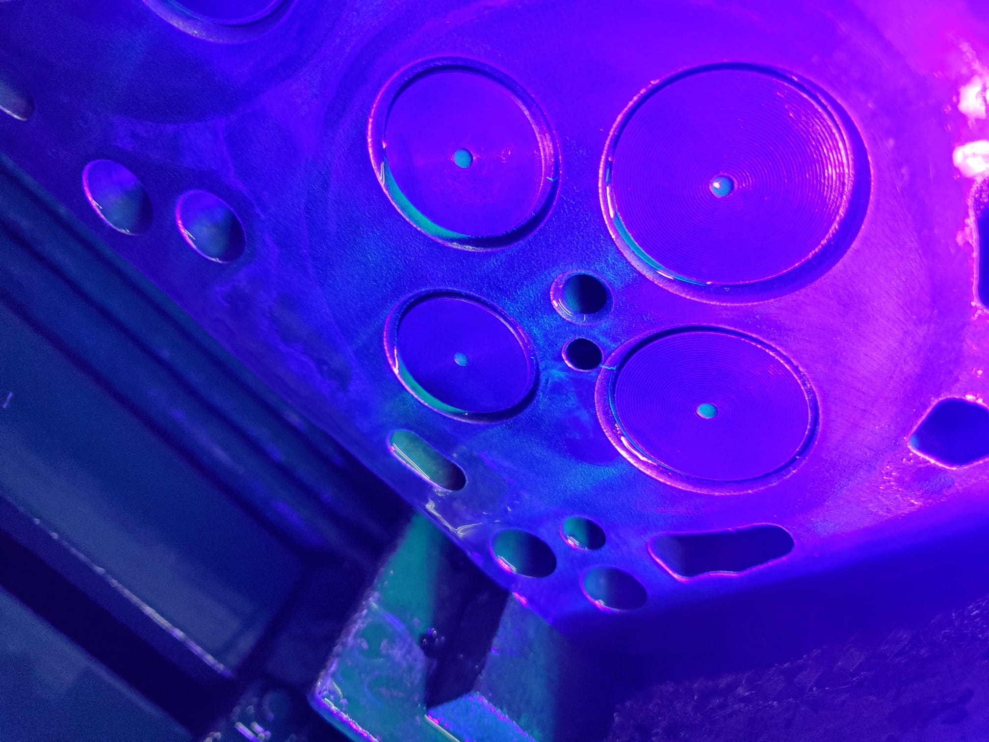 Technician performing magnaflux crack detection on a diesel engine component in a Miami machine shop.