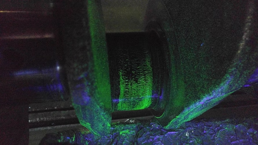 Diesel cylinder head undergoing magnaflux crack detection under UV light at Motor Service Group Miami